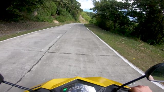 Fast moving hyperlapse of scooter or motorcycle rider travelling scenic roads of tropical Bohol island. Idyllic tranquil, freedom driving route with POV of speedometer & handlebars.