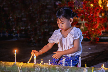 little girl is burning candles