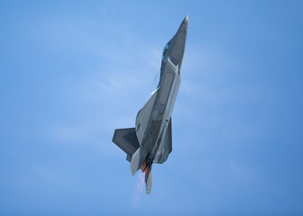 F-22 Raptor in a  high G climb in beautiful light , with condensation trails forming  around the...