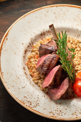 Knuckle meat dish with a side dish on a blue plate. Dark wooden background.
