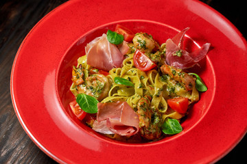 Pasta with shrimp and bacon. Dark wooden background. Restaurant menu