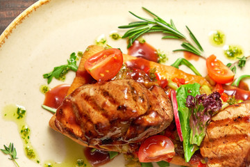 Grilled meat on pita bread on a bright oval plate. Dark wooden background. Restaurant menu