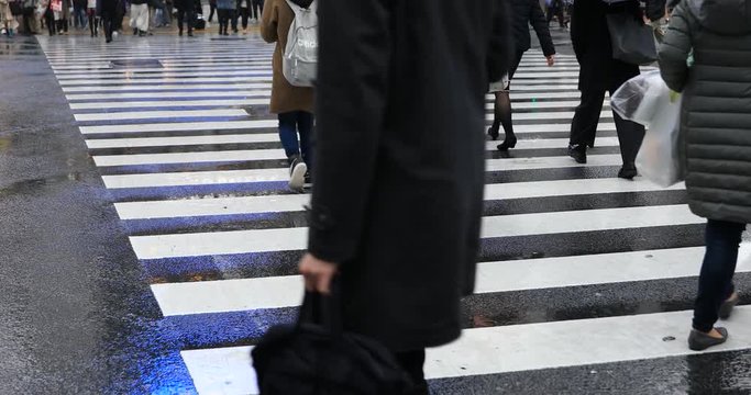 Walking people at Shibuya crossing in Tokyo rainy day