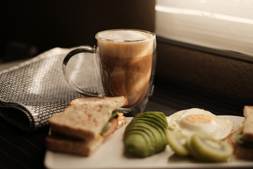 Breakfast and coffee on table with avocado egg and fruit . Healthy diet food.