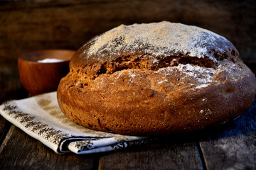 Rustic bread, towel the salt on a wooden old table.