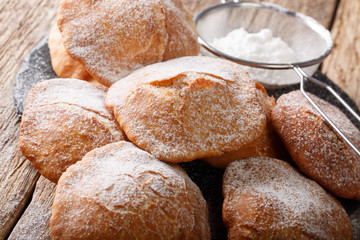Sweet deep-fried Bunuelos sprinkled with powdered sugar close-up. horizontal