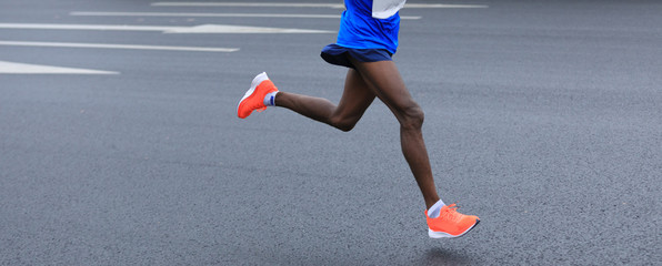 marathon runner legs running on city road © lzf