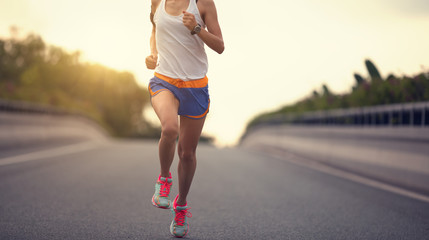 young fitness asian woman runner running on city road