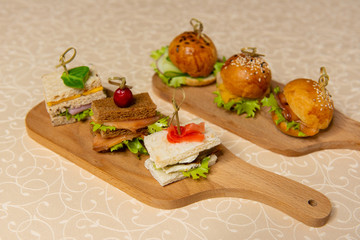 Small sandwiches and hamburgers on cutting boards in the interiors of the restaurant.