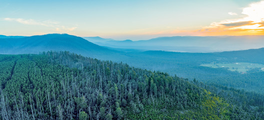 Aerial panoramic landscape of forest and mountains at sunset