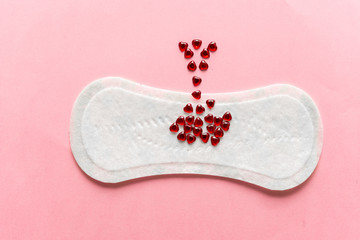 Feminine hygiene pad on a pink background. Concept of feminine hygiene during menstruation. top view.