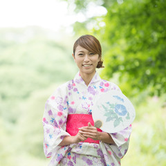 うちわを持ち微笑む浴衣姿の女性