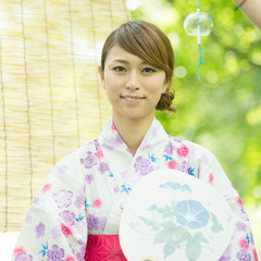 うちわを持ち微笑む浴衣姿の女性