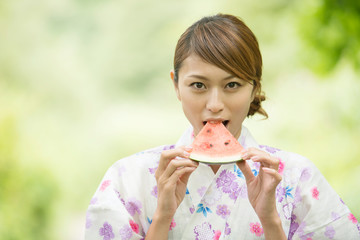 スイカを食べる浴衣姿の女性