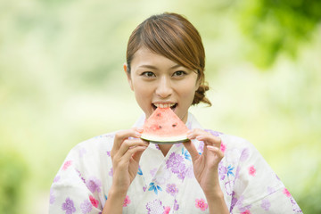 スイカを食べる浴衣姿の女性