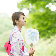うちわを持ち微笑む浴衣姿の女性