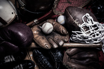 A large group of assorted vintage antique sports equipment. Including football helmet, baseball and...