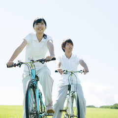 Obraz premium 草原で自転車に乗るカップル