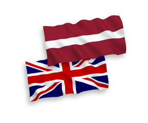 National vector fabric wave flags of Latvia and Great Britain isolated on white background. 1 to 2 proportion.