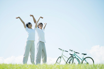 草原で深呼吸をするカップル