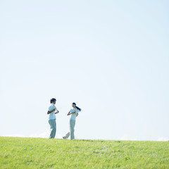 草原でジョギングをするカップル