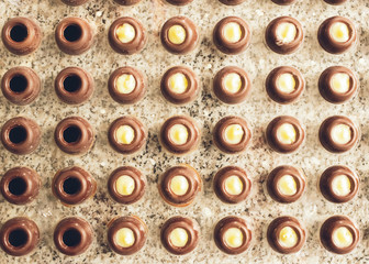 Dark chocolate candies are arranged in rows in special shapes. Cooking handmade chocolates. Horizontal frame.