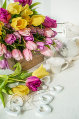 A beautiful bouquet of tulips with a white cup for tea. Close up