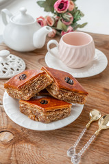 Traditional arabic dessert baklava with a cup of coffee, cashews, walnuts and cardamom on a wooden table. Homemade Baklava with Nuts and Honey