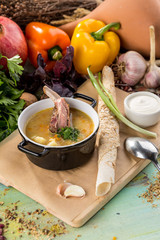 Shurpa soup with lamb in pot on blue wooden table