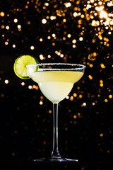 Classic daiquiri on the dark background with festive holiday bokeh.  Luxury craft drink concept. Vertical