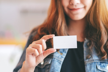 A beautiful woman holding and showing a blank empty business card to someone