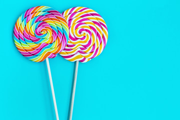 striped spiral multicolor Lollipop on blue background close up