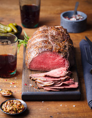 Roast beef on cutting board. Wooden background.