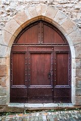 Medieval brown door and pointed stone arch of Gothic architecture