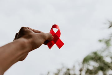 Red ribbon for world aids day awareness campaign background. - obrazy, fototapety, plakaty