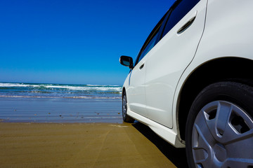 Car facing the sea on the beach. ビーチで海と向かい合う自動車