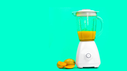 mango juice with a blender, isolated on a green background