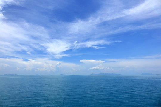 Blue ocean with blue sye and white clouds background. Beautiful seascape