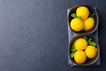 Mango ice cream, tropical fruit sorbet in black bowl on slate background. Copy space. Top view.