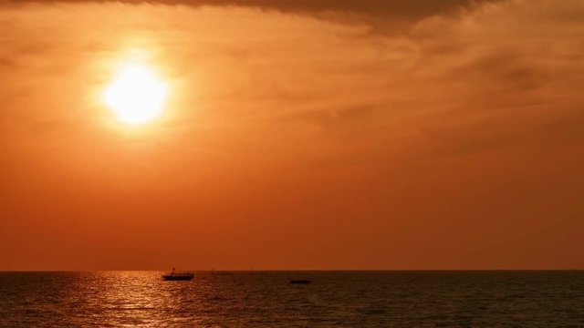 Scenic red orange sunset over asian sea in tropical climate. Rich colors and quite weather makes all the picture very calm and epic. Timelapse  is made from around one hour photo shots