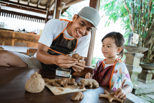 Asian Father And Daughter Making Pottery Together With Clay