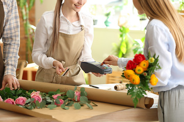 Woman paying for order in flower shop