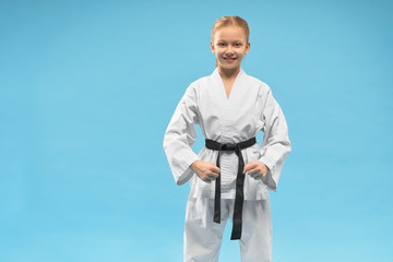 Girl wearing white kimono and black belt on blue background © serhiibobyk