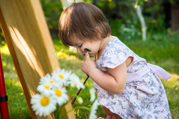 little girl is drawing. Young artist. Painting.  Girl in the park. activity for children. Summer fun kids