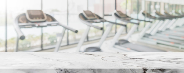 Empty white marble stone table top on blurred with bokeh Exercise room,fitnees and gym interior banner background - can be used for display or montage your product.