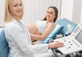 Fototapeta premium View from side of pretty female doctor looking at camera