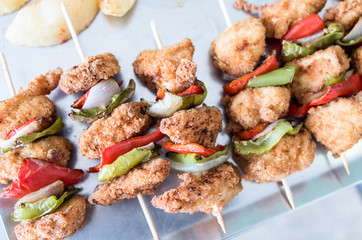 Chicken brochettes battered in bread crumbs and flour with onion and red and green pepperChicken brochettes battered
