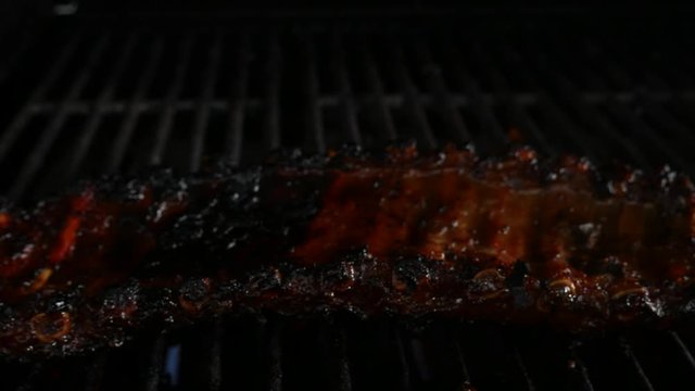Close up of ribs onto the grill and closing the stainless steel lid lid