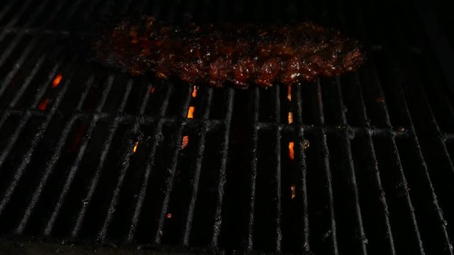 Putting a rack of ribs onto the grill and closing the stainless steel lid lid
