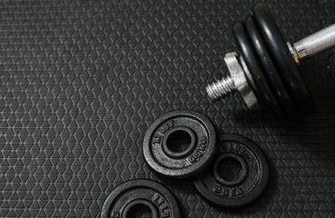 Naklejka na ściany i meble Iron dumbbells or weights on black floor with copy space for text. Health care concept.